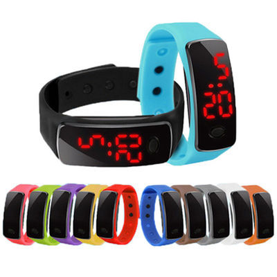 Los niños ligeros llevados de la pulsera miran el reloj de la pulsera de la goma de silicona