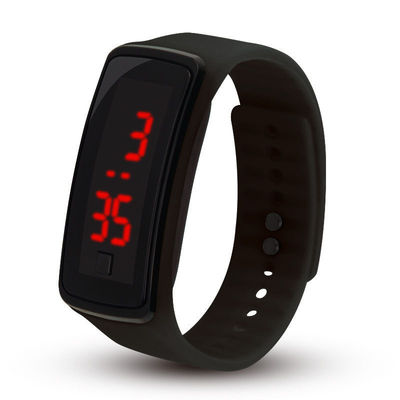 Los niños ligeros llevados de la pulsera miran el reloj de la pulsera de la goma de silicona